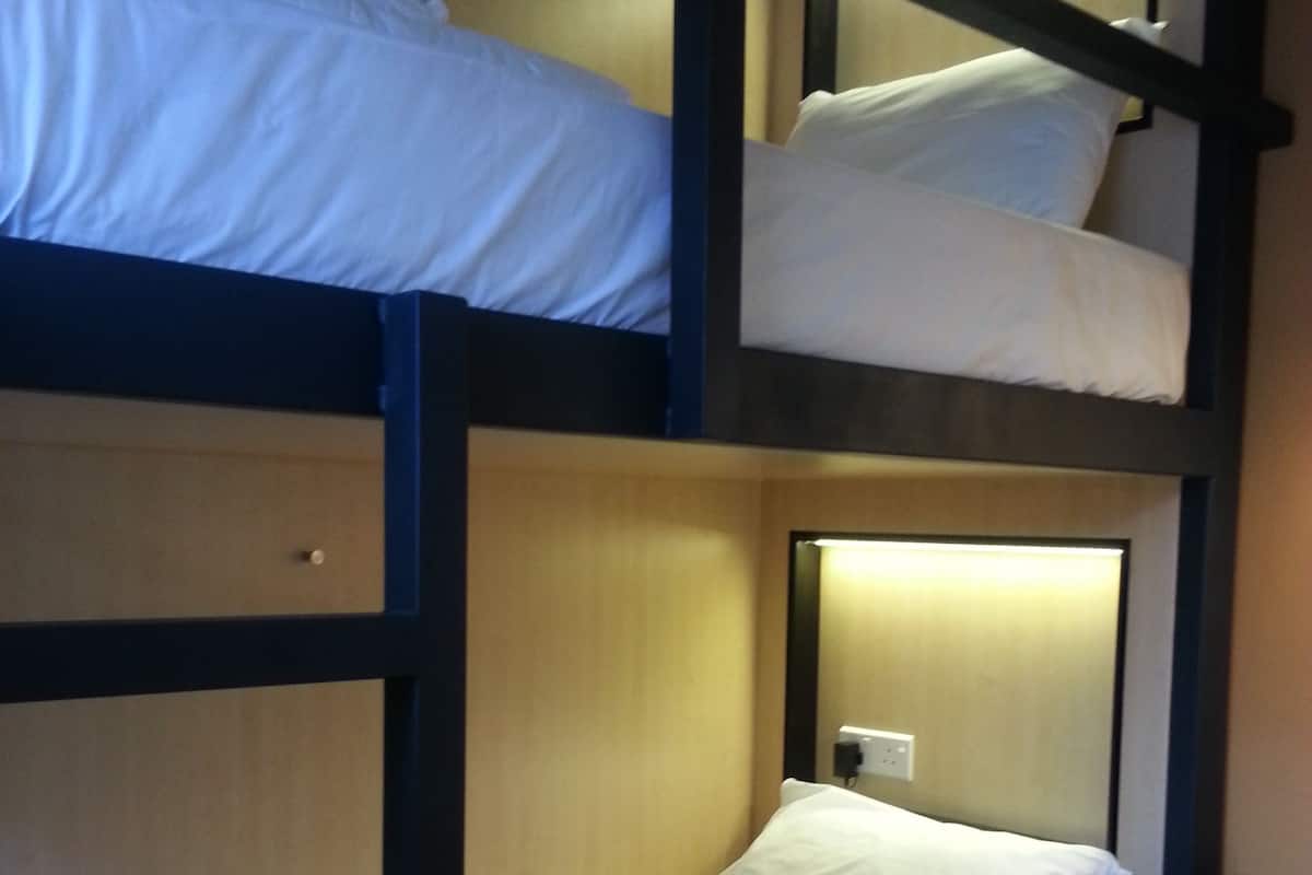 A bunk bed room with a desk and chair.