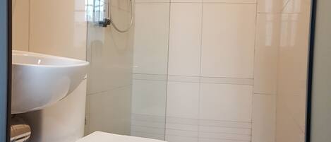 Ein Badezimmer mit Toilette, Waschbecken und Dusche.