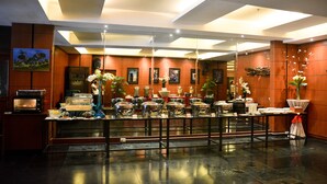 A hotel lobby with a buffet setup, a microwave, and a large mirror reflecting the room. - Citystate Tower Hotel (Manila)
