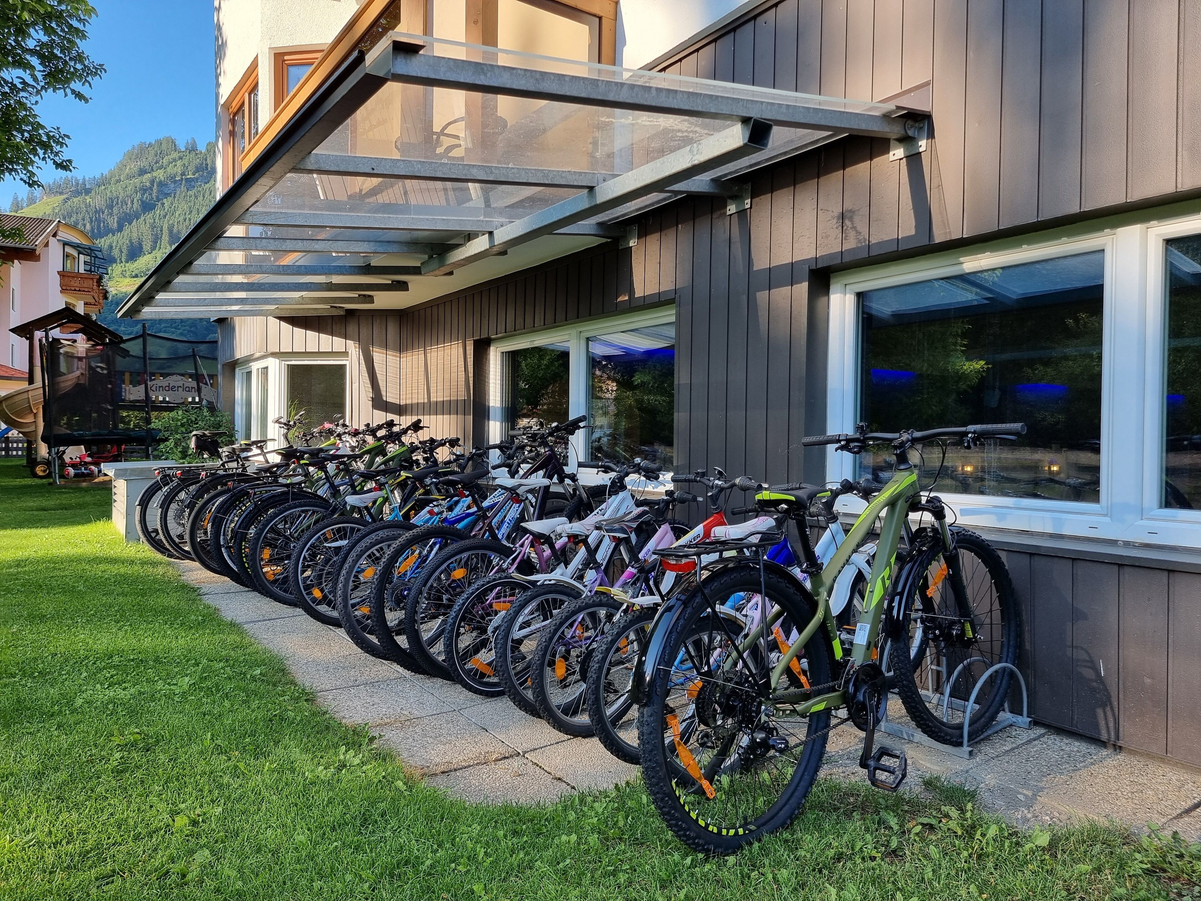 Una serie di biciclette parcheggiate di fronte a un edificio con una tettoia.