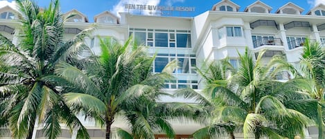 A multi-story hotel with a sign reading "Ben Tre Riverside Resort."