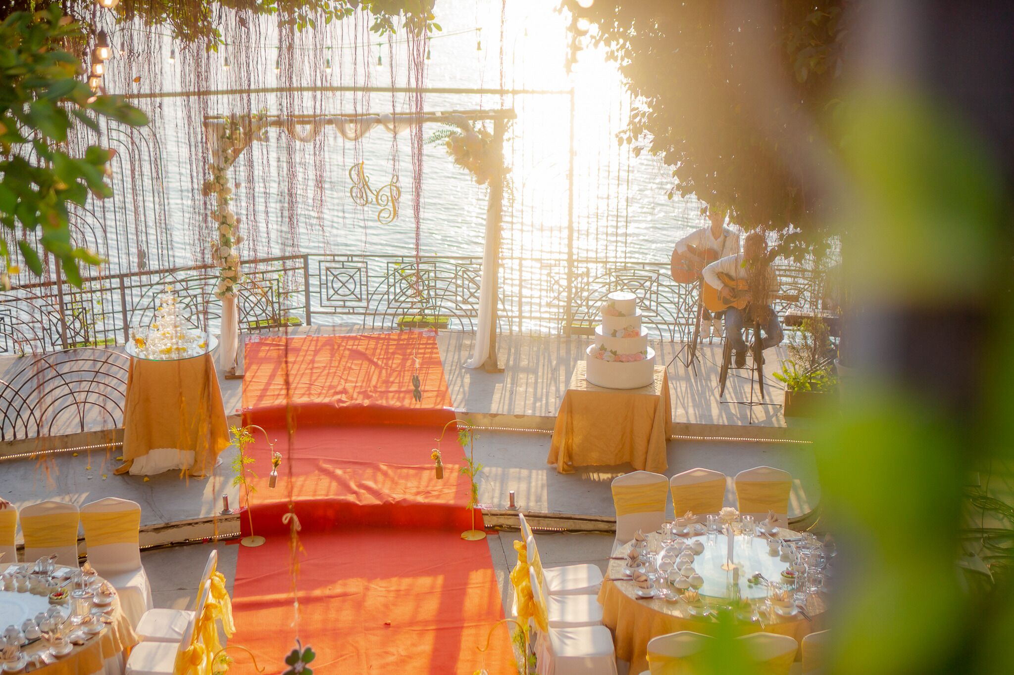 An outdoor wedding setup with a stage, tables, and chairs arranged for guests.