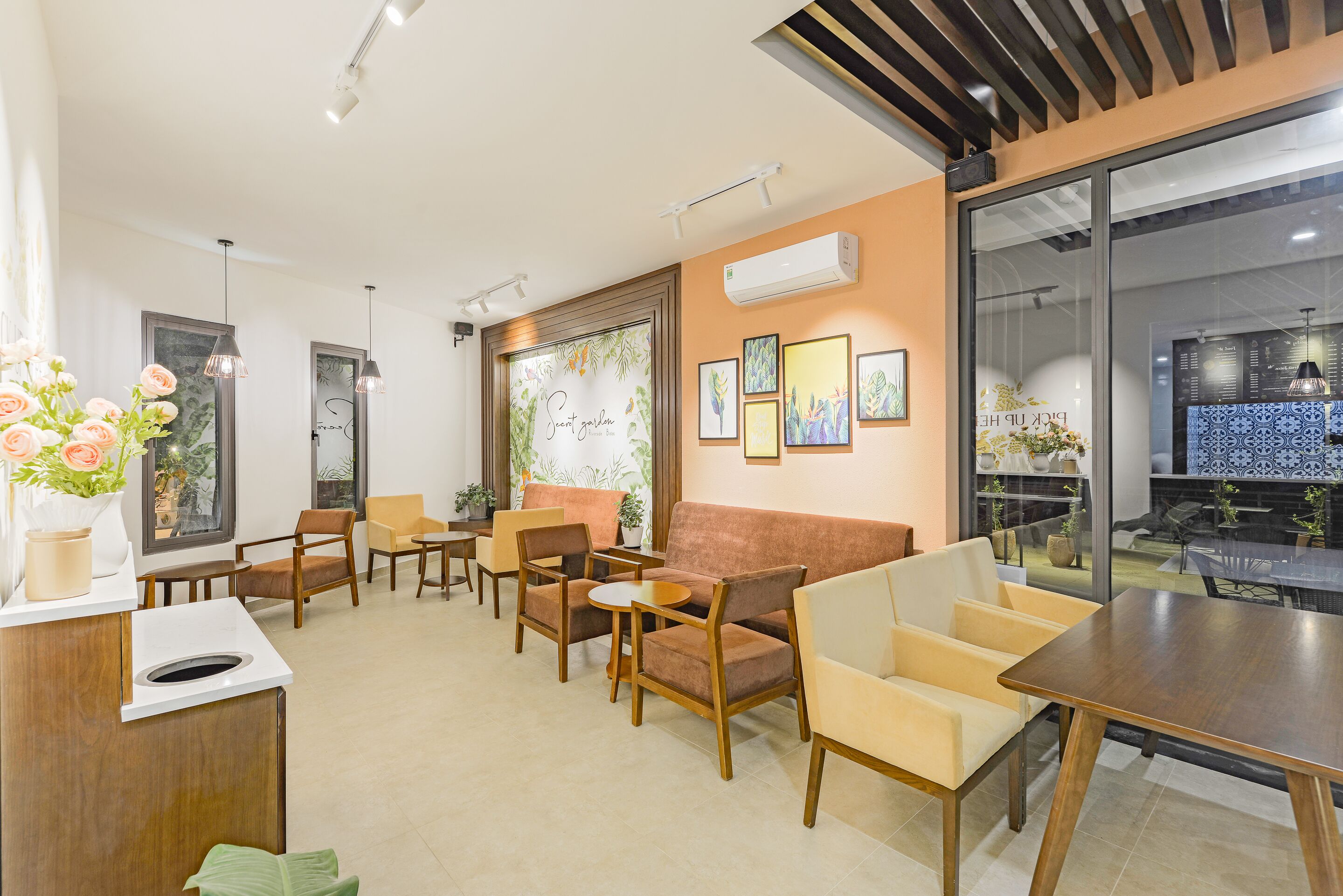 A modern interior with a sofa, chairs, a table, and a reception desk.
