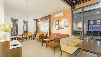 A modern interior with a sofa, chairs, a table, and a reception desk.