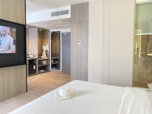 A modern hotel room with a bed, a TV, a wardrobe, and a bathroom. - Swiss-Belexpress Jemursari (Surabaya)