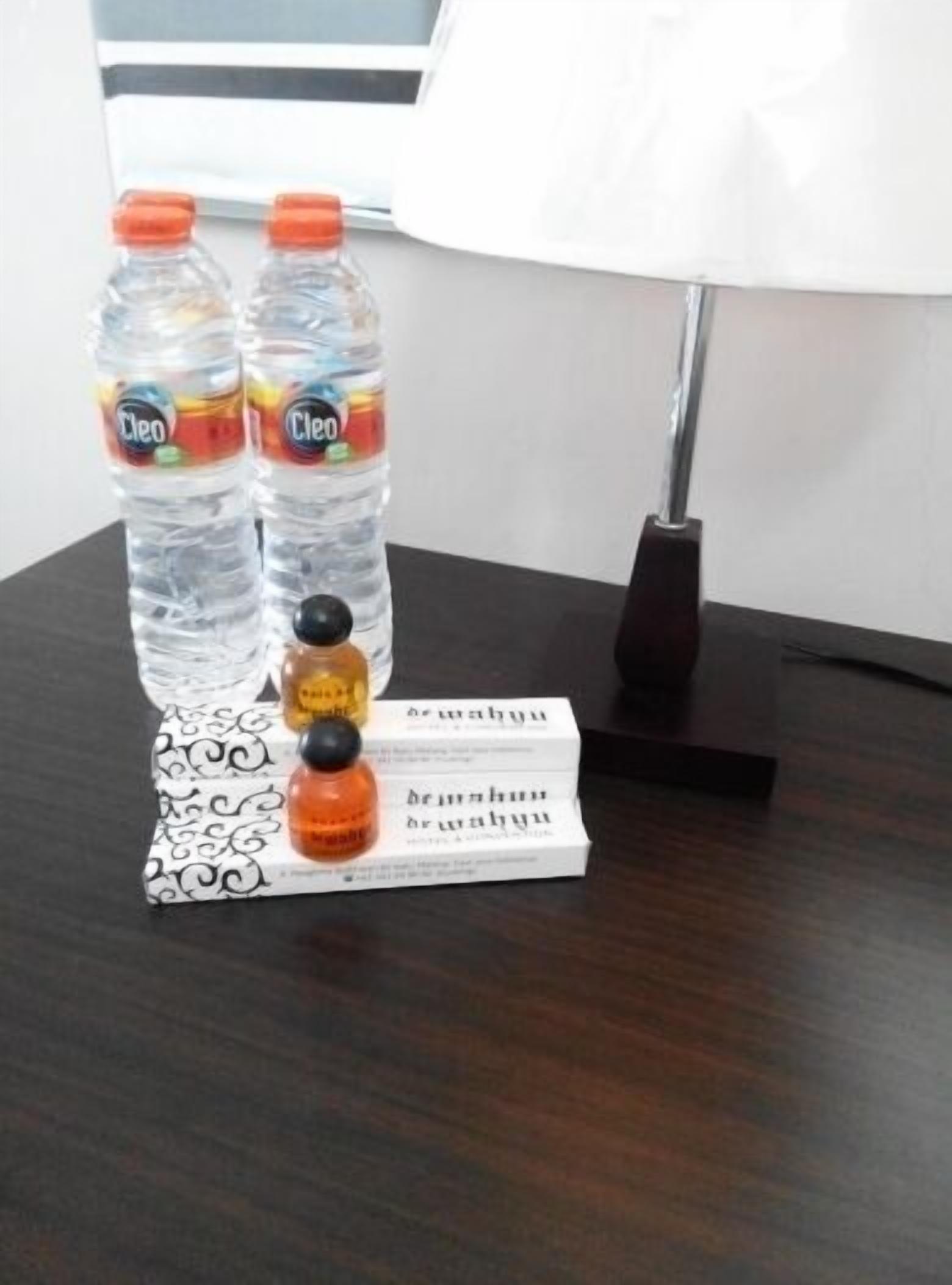 Une table avec deux bouteilles d’eau, une bouteille de jus d’orange et une boîte de thé.