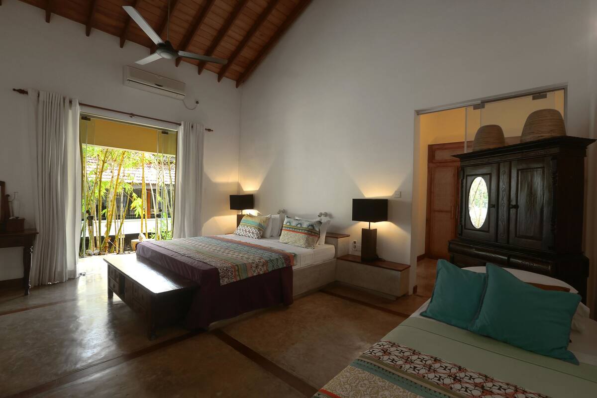 A bedroom with a bed, bedside tables, a wardrobe, and a sliding door to a balcony.