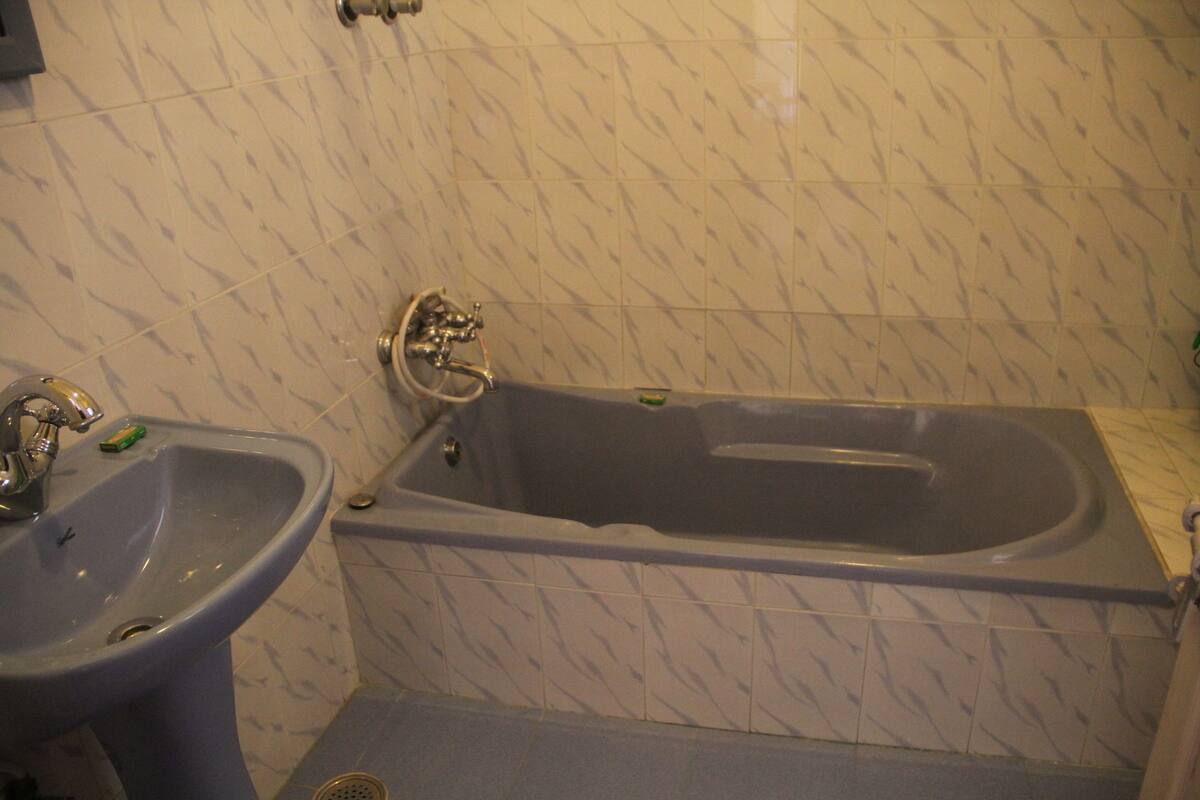 A bathroom with a sink, bathtub, and tiled walls.