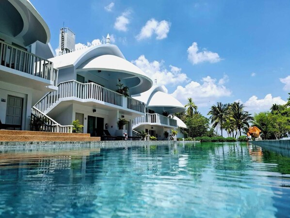Experience the unique architecture and tranquil atmosphere of this hotel, surrounded by lush greenery and a serene swimming pool.