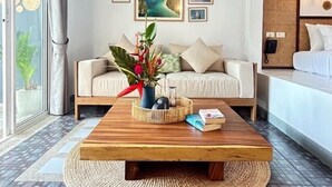 Un salon moderne avec un canapé, une table basse et des œuvres d’art accrochées au mur.