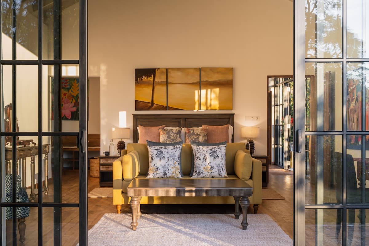 A living room with a sofa, a coffee table, and a painting above the sofa.