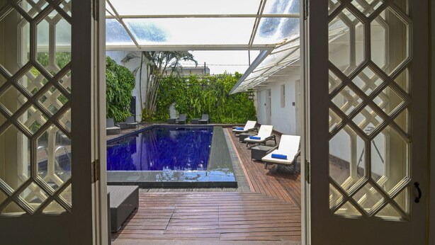 A view of a swimming pool with lounge chairs and a wooden deck. - Deco On 44 (Galle)