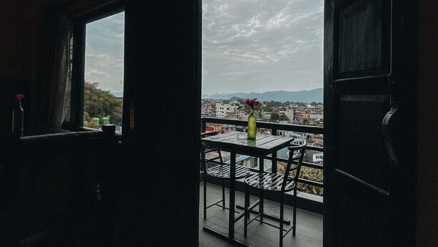 Un espacio interior con vistas a un paisaje urbano a través de un amplio ventanal.