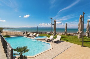 Una piscina al aire libre de temporada, sombrillas