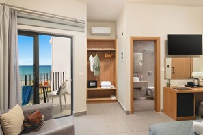 Une chambre d’hôtel moderne dotée d’un balcon, d’un dressing, d’une salle de bain et d’une télévision.