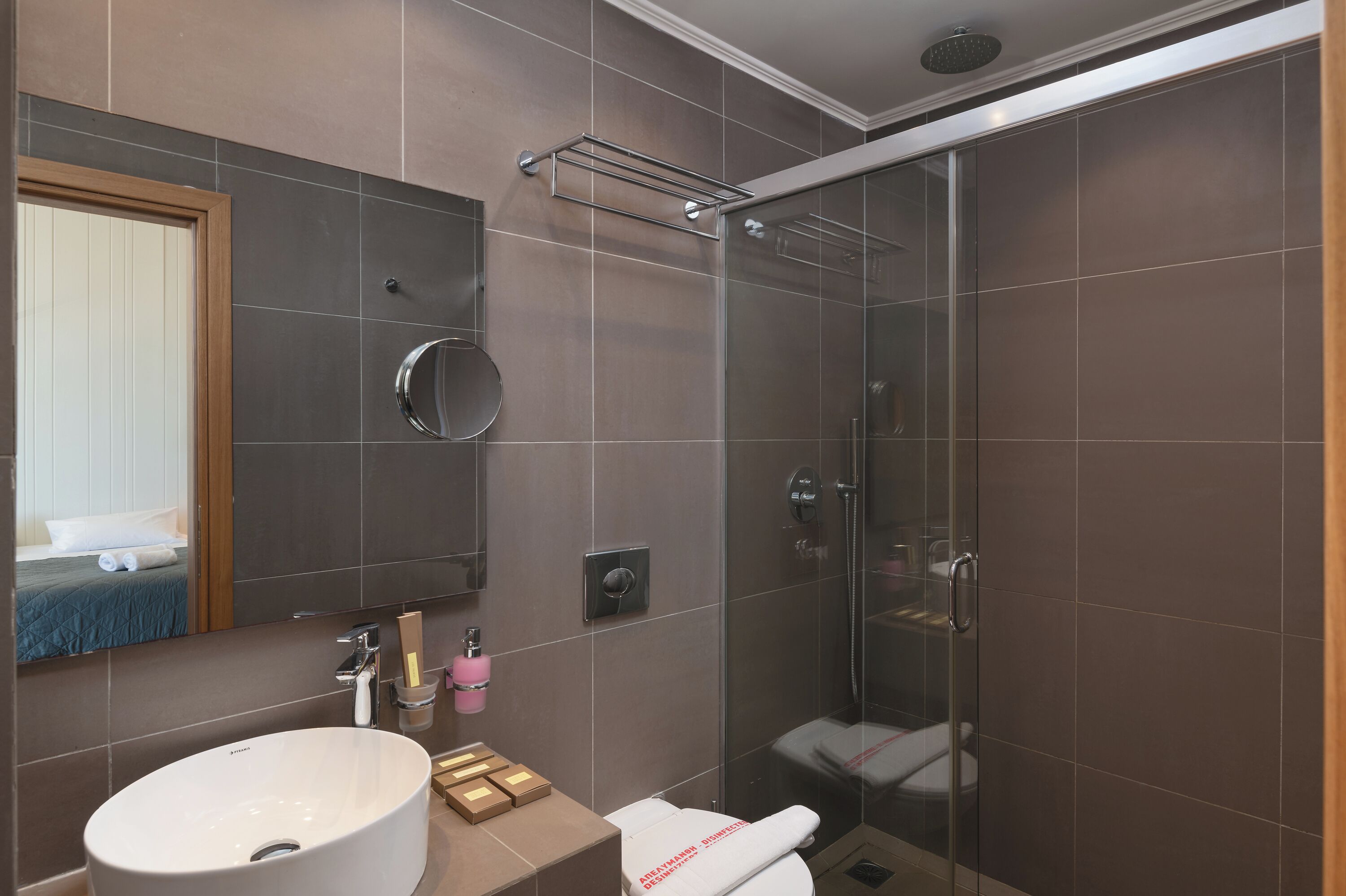 A modern bathroom with a large sink, mirror, and shower.