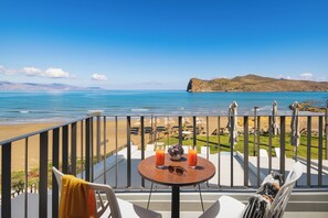 Un balcon avec une table, deux boissons et une paire de lunettes de soleil.