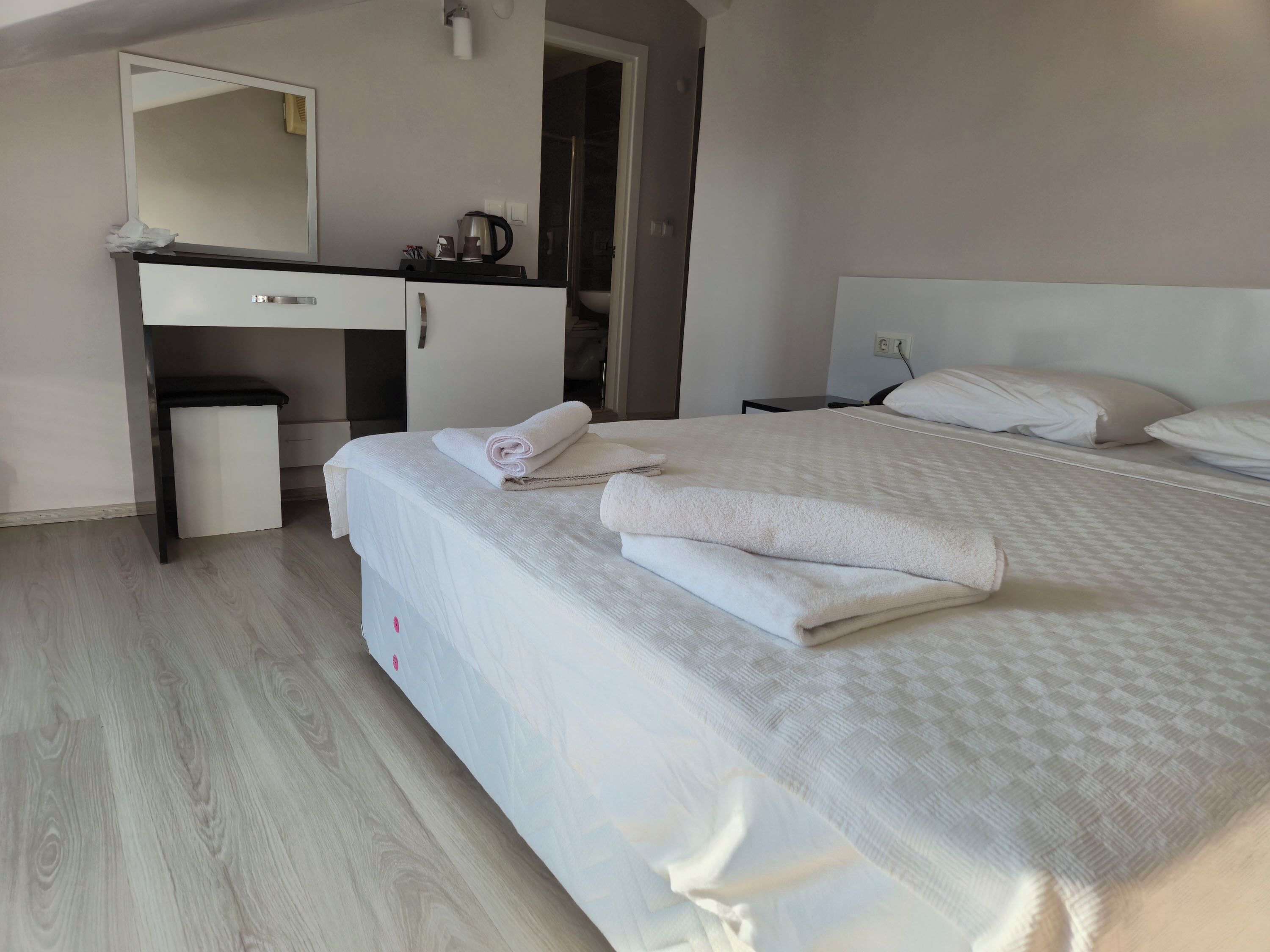 Ein Hotelzimmer mit Bett, Schreibtisch und Spiegel.