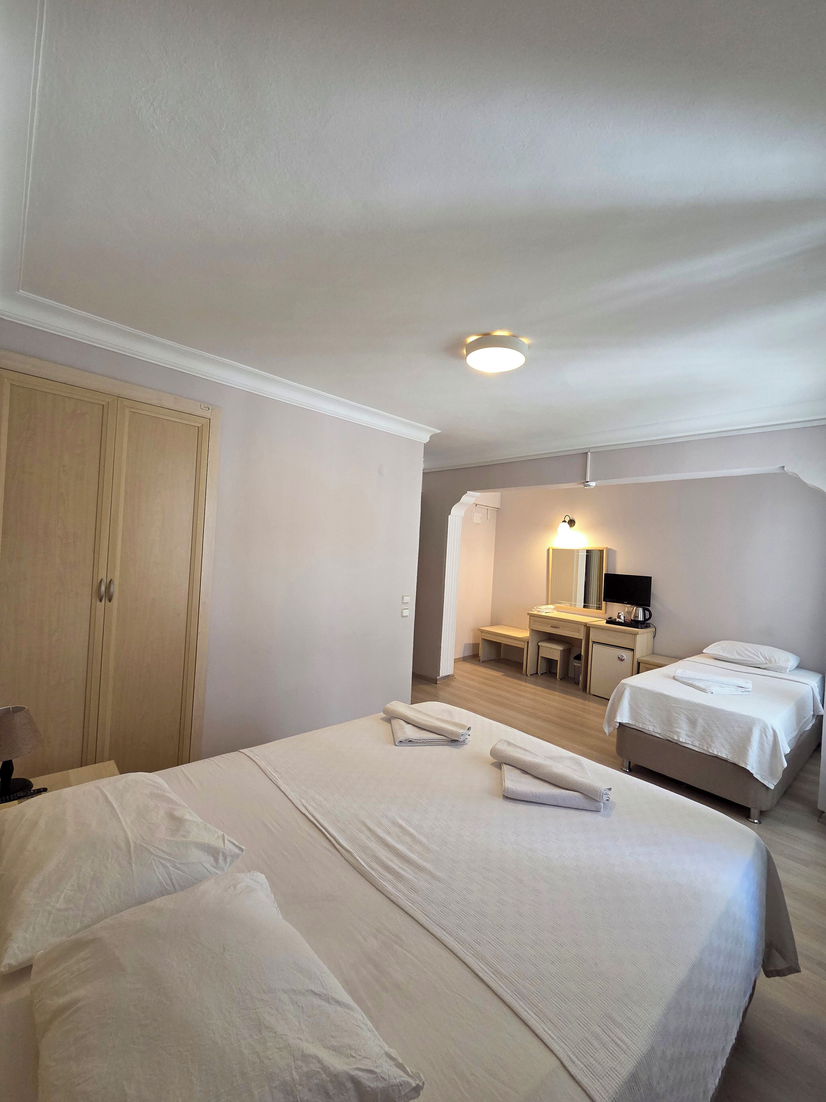 Habitación de hotel con una cama grande, un escritorio, una silla, un armario y un baño.