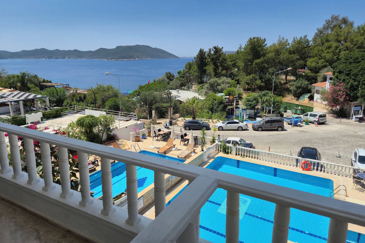 Uma área de piscina com vista para o mar e montanhas.