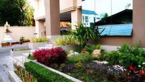 A landscaped garden area with various plants and a fountain. - Tongtip Place (Bangkok)