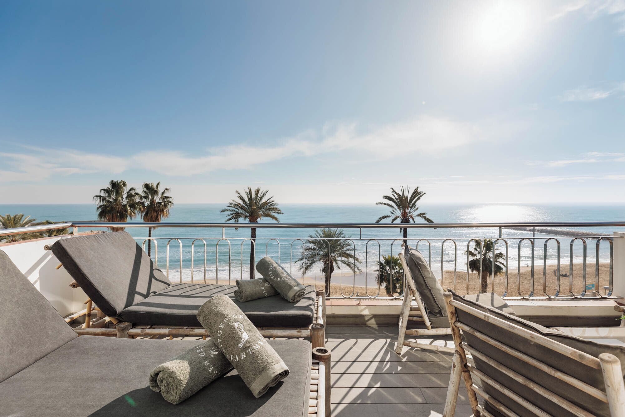 Ein Balkon mit Liegestühlen und Blick auf den Strand.