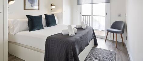 Une chambre à coucher moderne avec un grand lit, un bureau et une chaise.