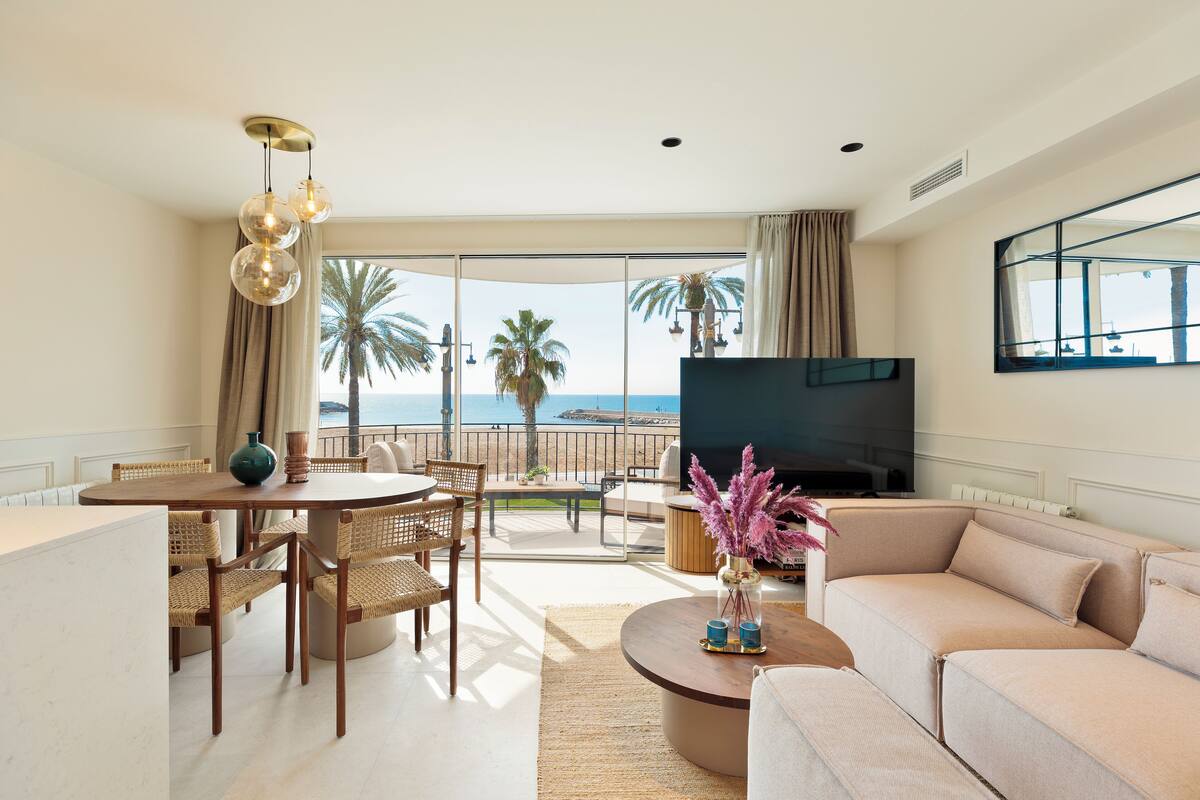 Een ruime woonkamer met een balkon, een eethoek en een televisie.