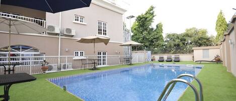 Alberca al aire libre y camastros