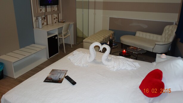 Une chambre d’hôtel avec un lit, une télévision, un bureau et un canapé.