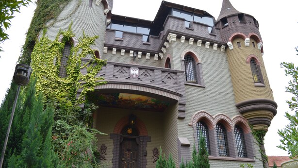 A castle-like building with a turret, arched windows, and ivy-covered walls. - Castillo Medieval (Vina del Mar)