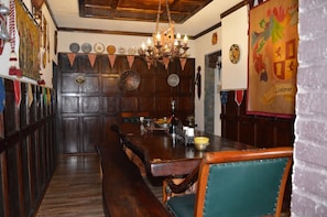 A traditional dining area with wooden furniture, a chandelier, and a banner with the word "Liebner". - Castillo Medieval (Vina del Mar)