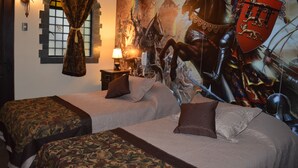 A bedroom with two beds, a large tapestry, and a castle-themed mural. - Castillo Medieval (Vina del Mar)