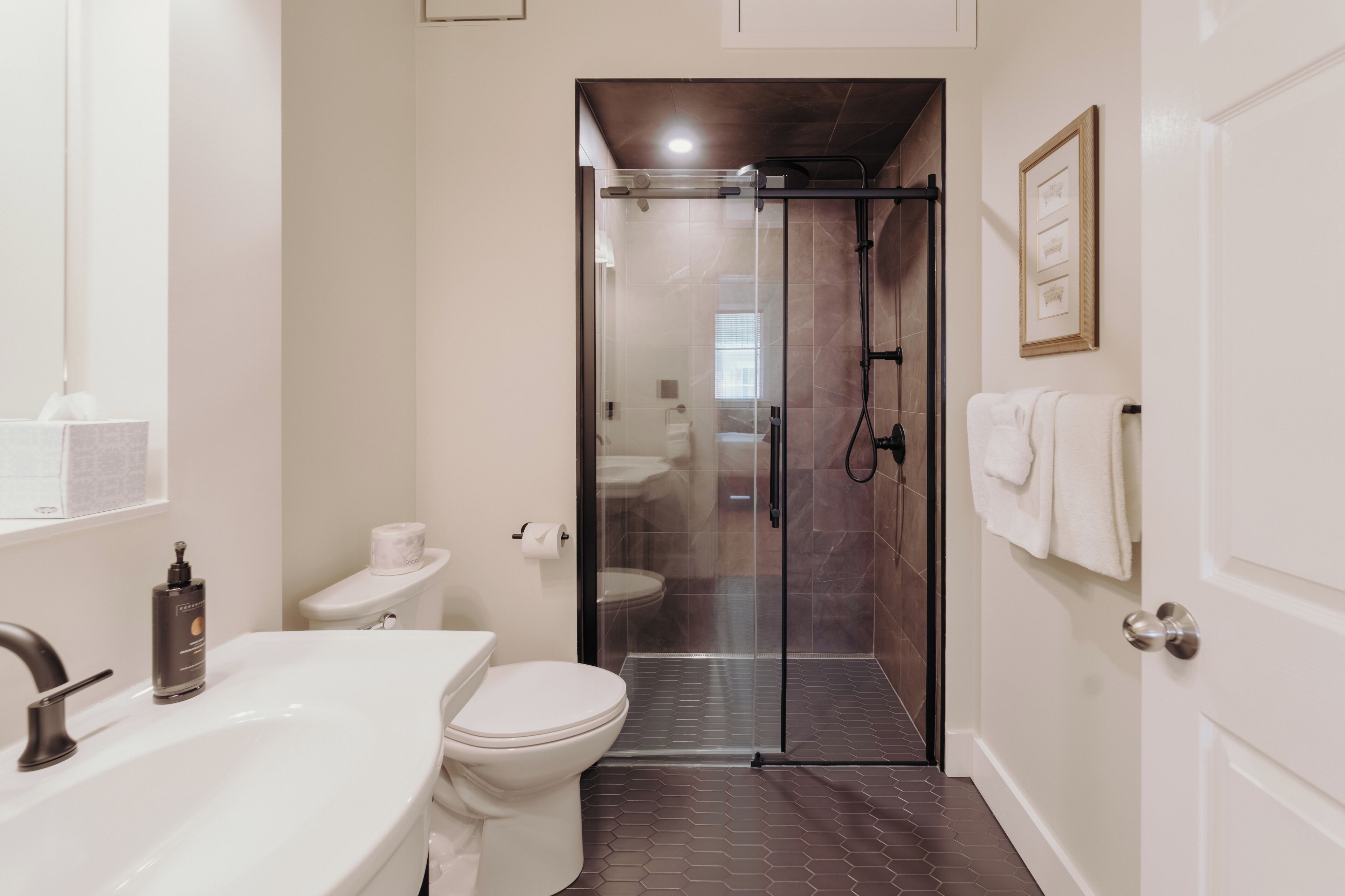 A bathroom with a shower, toilet, and sink.