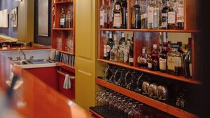 A bar area with shelves of liquor bottles and glasses.