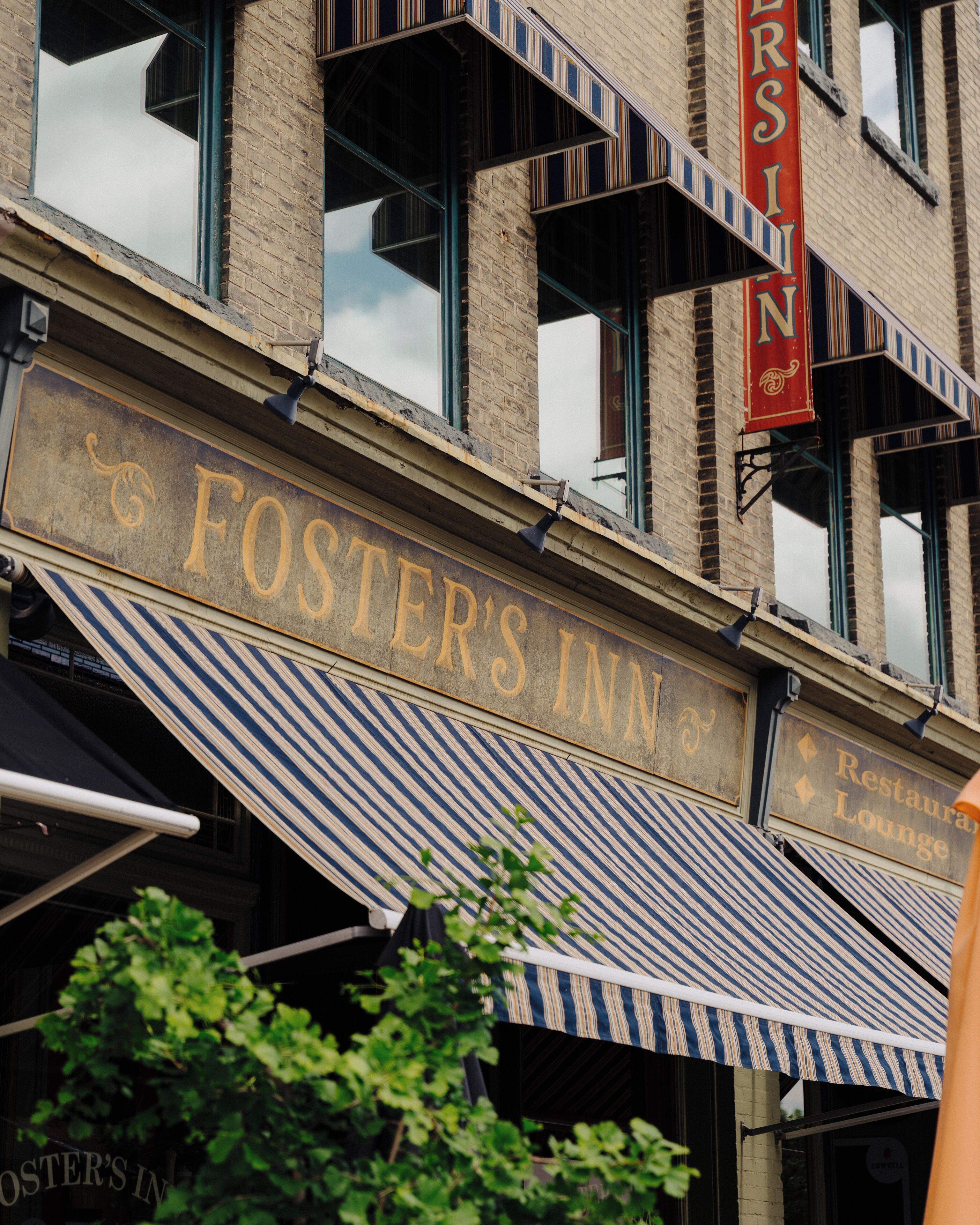 Un edificio con un letrero que dice 'Foster's Inn' y un toldo a rayas.
