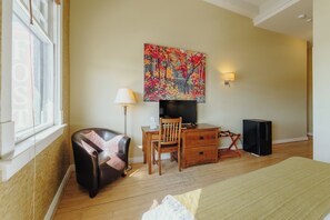 Relax in a spacious room with a comfortable bed, desk, and flat-screen TV.
