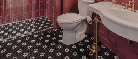 A bathroom with a shower, toilet, and sink.
