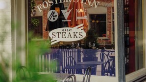 A restaurant window with the name 'Foster's Inn' and the tagline 'Great Steaks' visible.