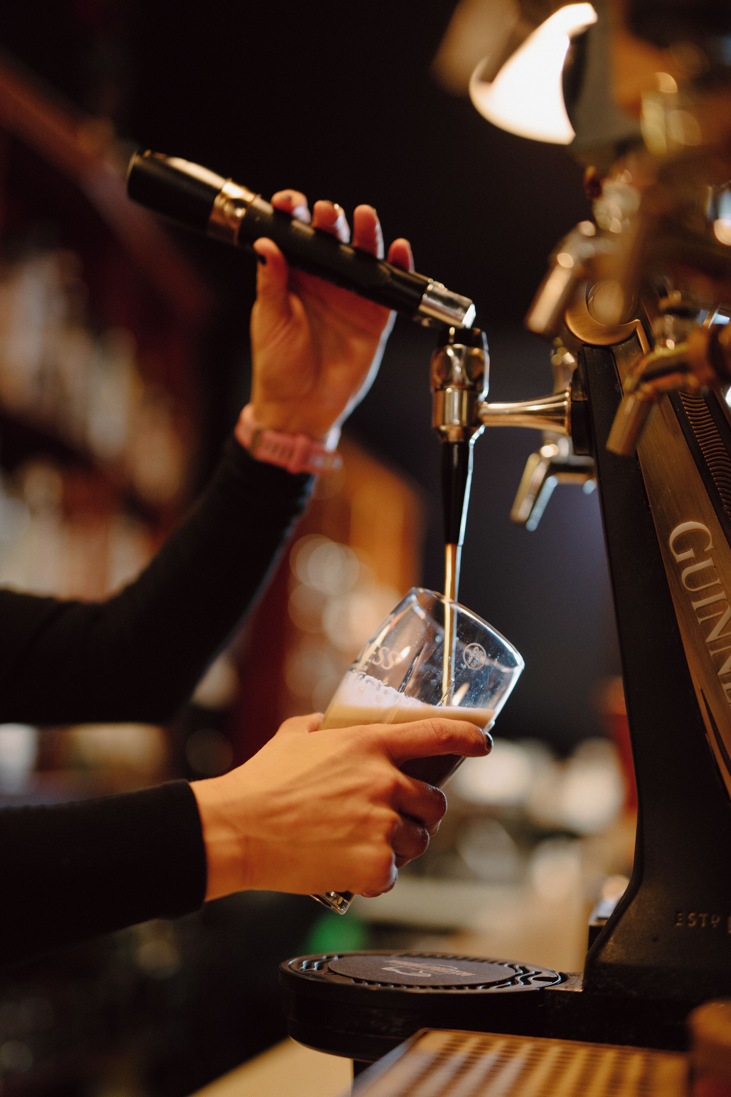 Une personne utilise une machine à café et verse une boisson dans un verre.