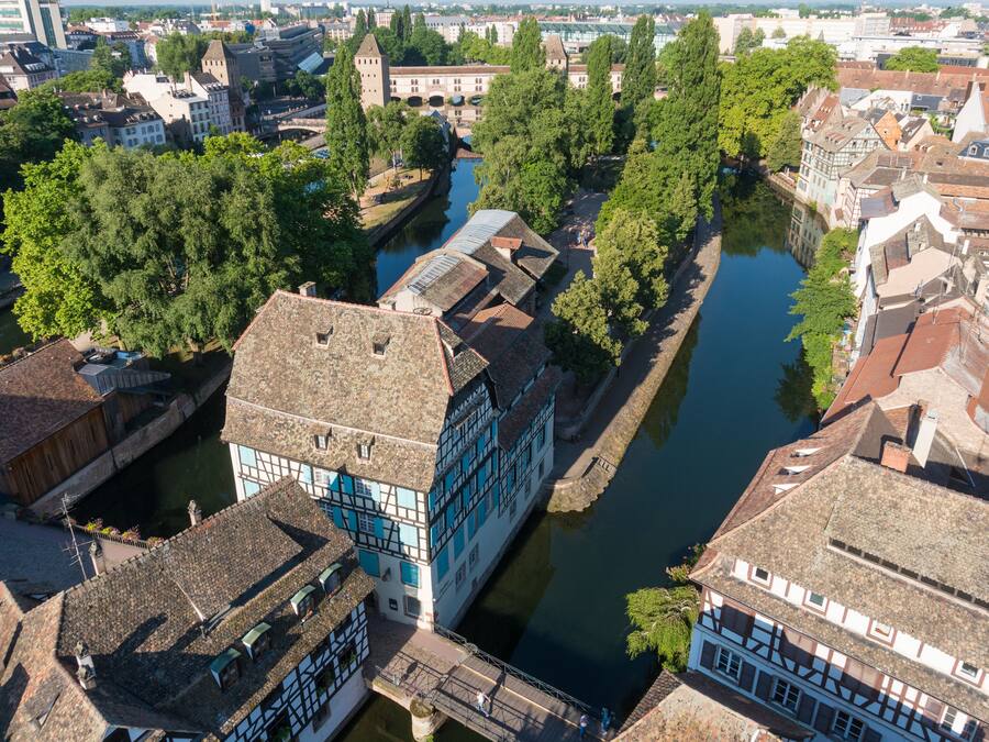 Luchtbeeld van een historische stad met smalle waterwegen, traditionele gebouwen en een opvallende brug.