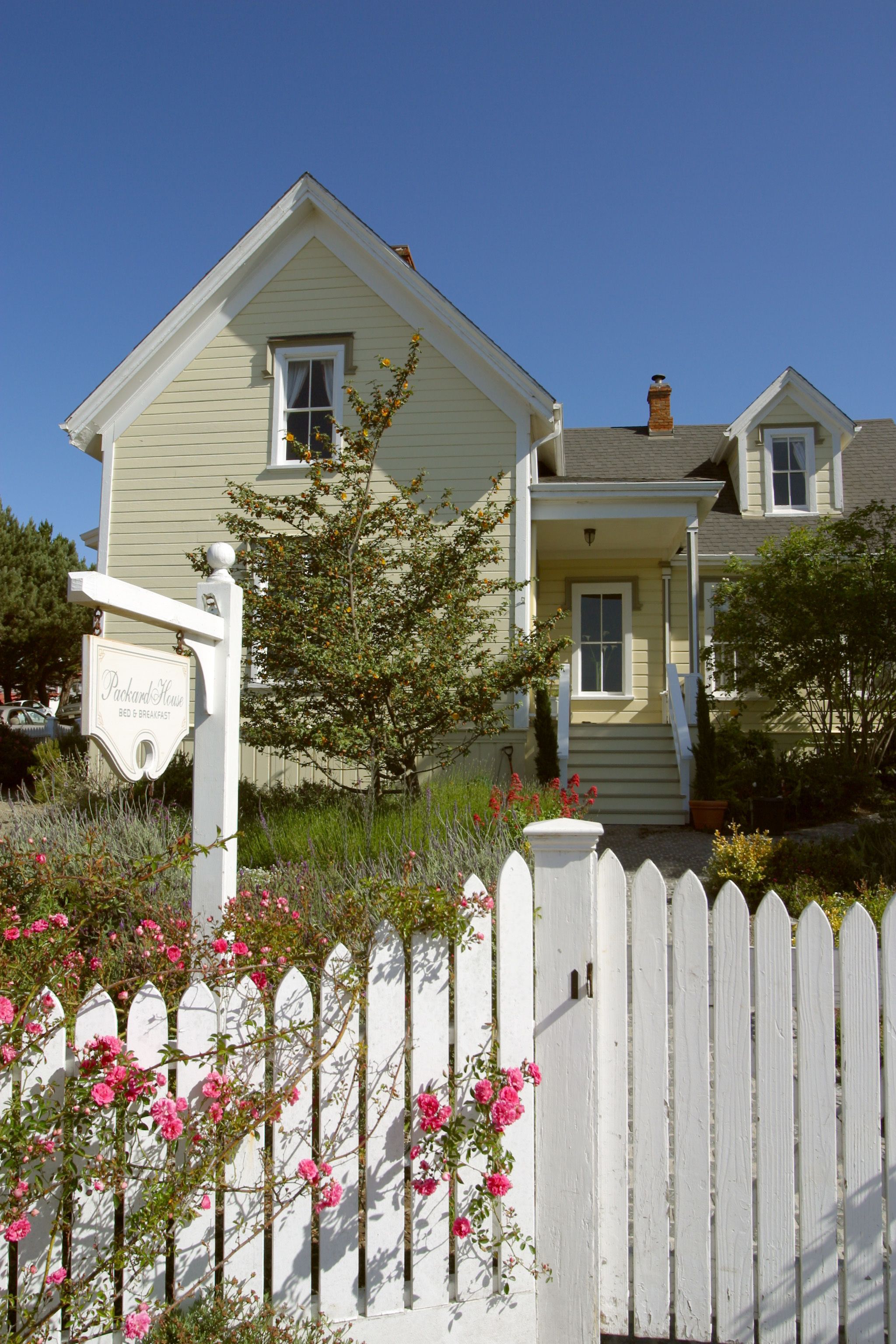 A two-story house with a porch and a sign that reads "Packard House Bed & Breakfast."