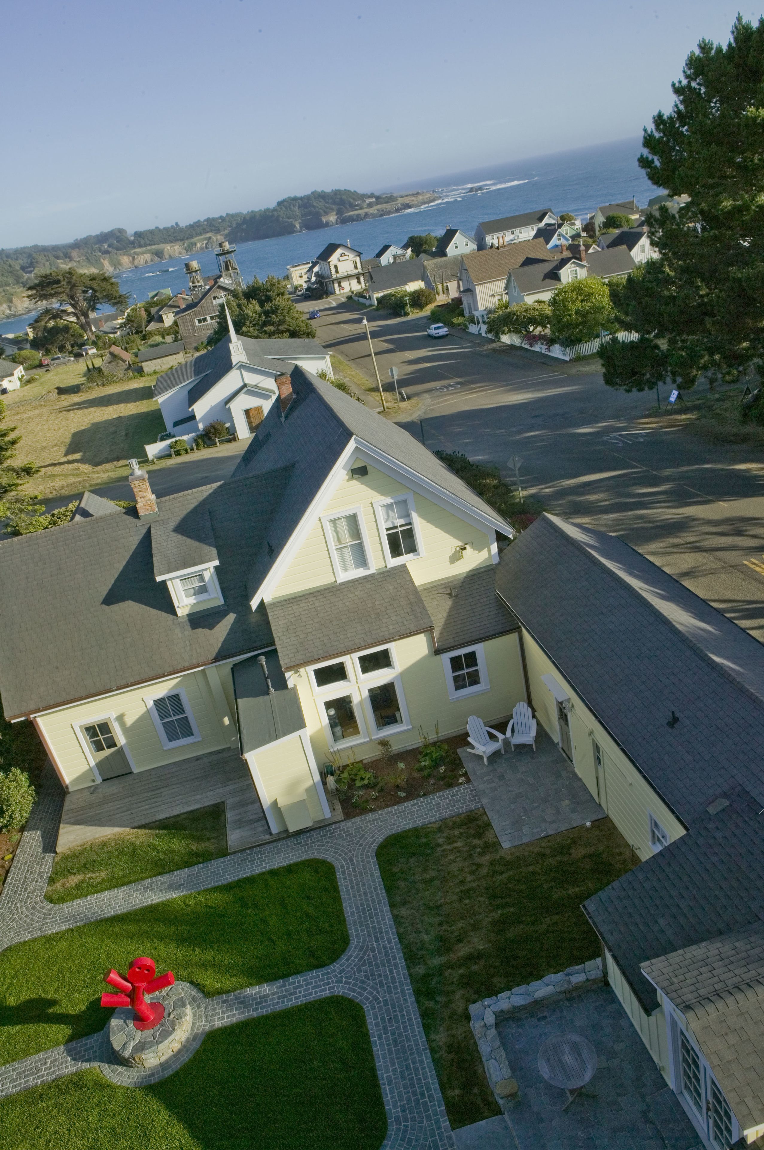 A residential area with houses, a paved driveway, and a grassy lawn.