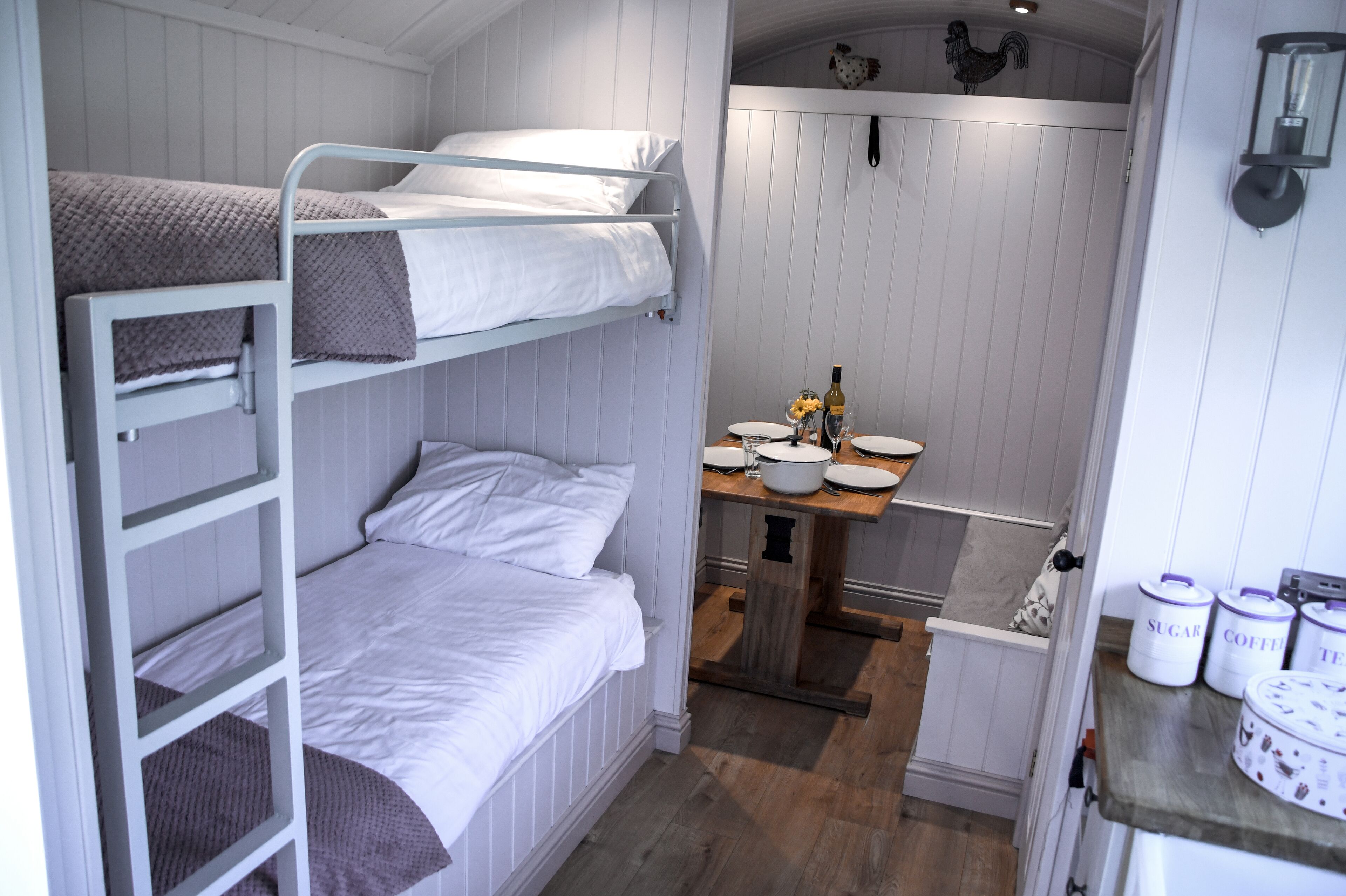 A bunk bed room with a small kitchenette.
