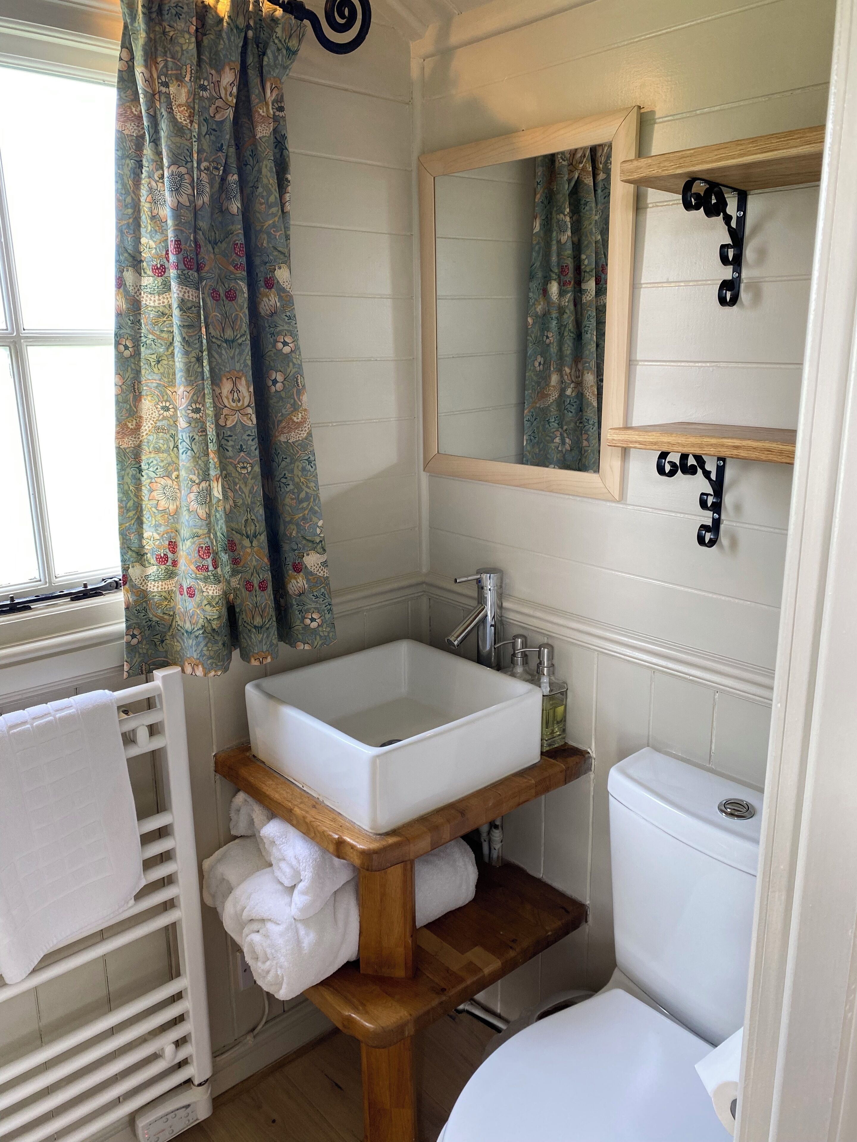 Une salle de bain avec un lavabo blanc, un meuble-lavabo en bois et des toilettes.