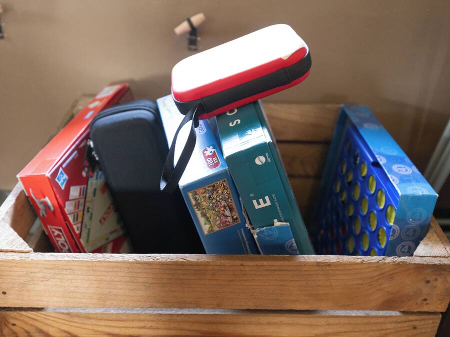 A wooden crate filled with various electronic devices and boxes.