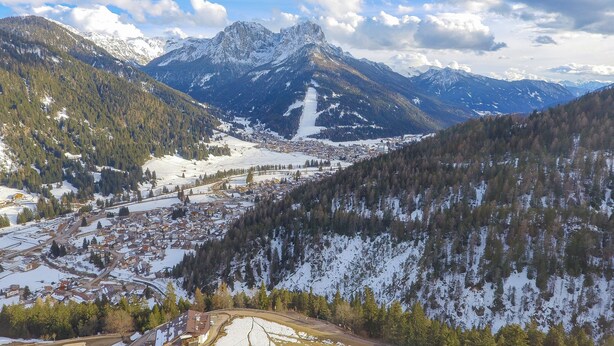 Un paysage montagneux avec une ville nichée au fond de la vallée.