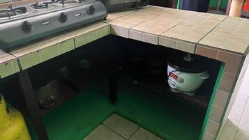A compact kitchen with a gas stove, a microwave, and a built-in oven.