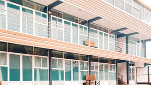 Een modern gebouw met een plat dak, grote ramen en een balkon.