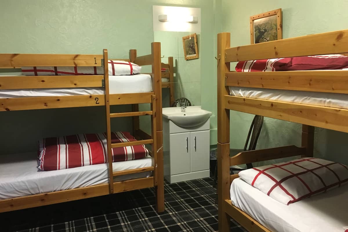 A bunk bed room with a sink and a mirror.